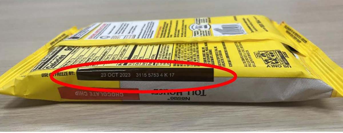 A yellow package of the Nestlé Toll House Chocolate Chip Cookie Dough Bar with a red indicator circling where to look for the date on the back.