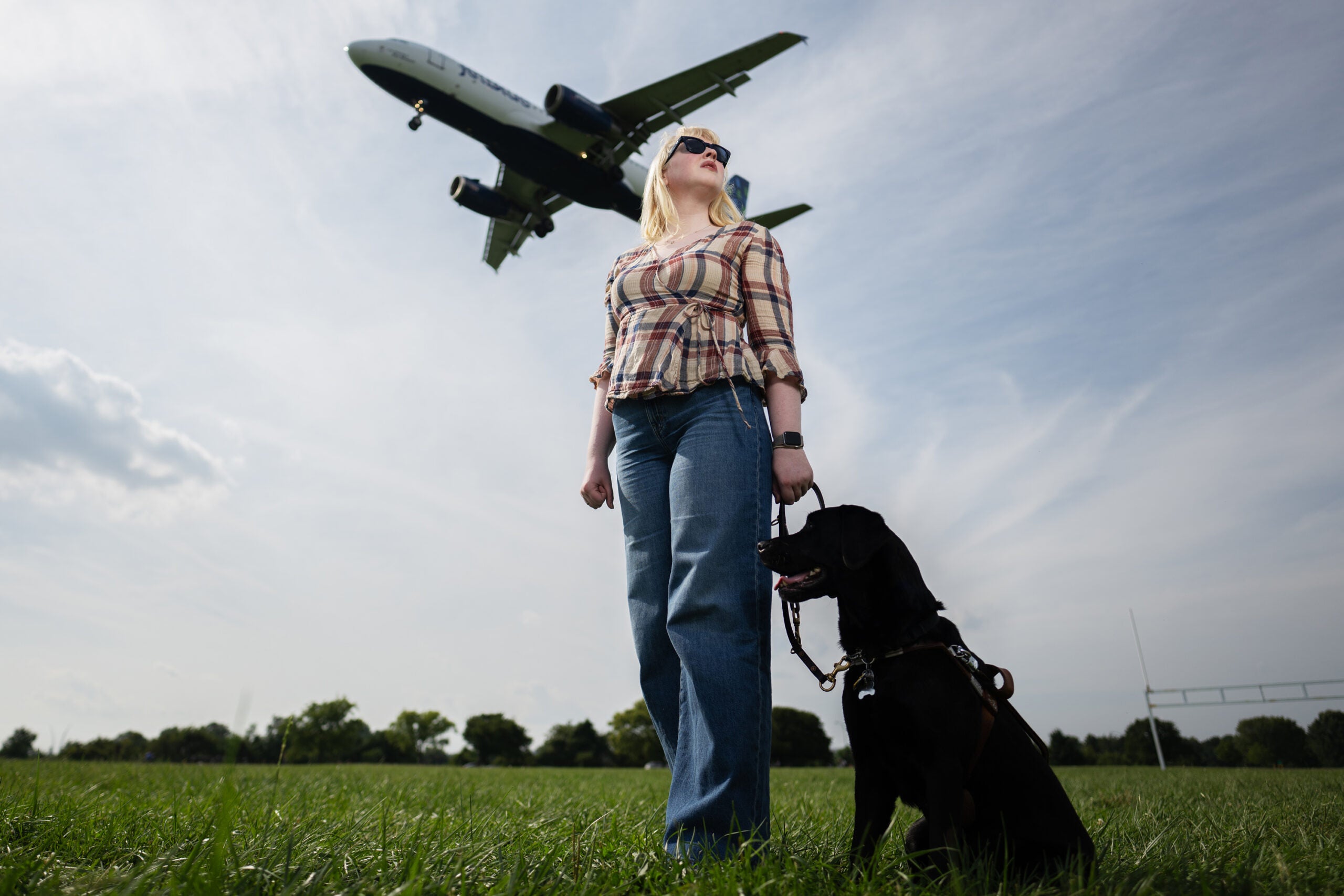 Elizabeth Schoen with her black Labrador service dog, Eva, at Gravelly Point Park near Reagan National Airport in Arlington, Va.