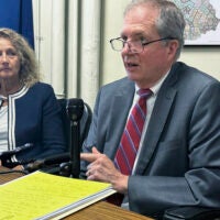 New Hampshire Deputy Secretary of State Patricia Lovejoy looks on as Secretary of State David Scanlan talks.
